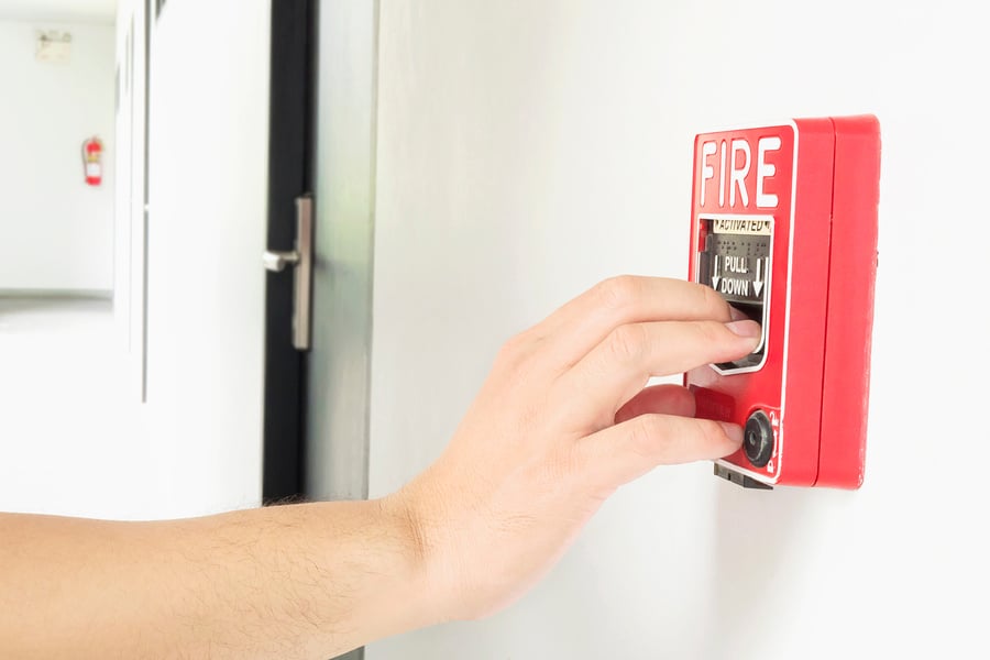 Man Reaching His Hand to Push Fire Alarm